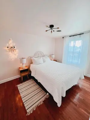 a bedroom with a white bed and a window at Cozy House