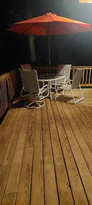 two chairs and a table and an umbrella on a deck at Forest View in Paradise