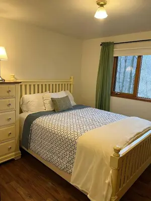 a bedroom with a bed with a dresser and a window at Forest View in Paradise