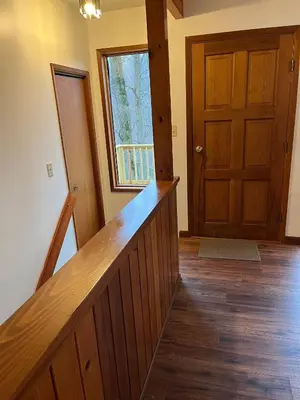 a hallway with a wooden staircase and a door at Forest View in Paradise