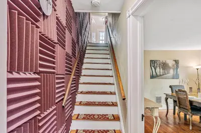 a staircase in a home with red wood panels at NEW - Mainline Train, Colleges, Hospital in Bryn Mawr