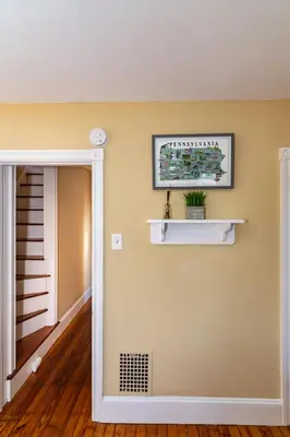 a room with a mirror and a shelf on the wall at NEW - Mainline Train, Colleges, Hospital in Bryn Mawr