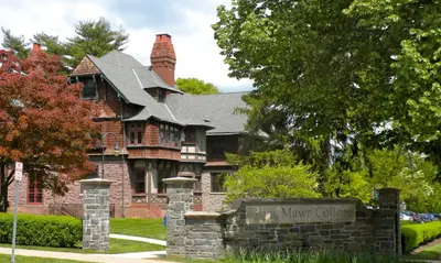 a large brick house with a sign in front of it at NEW - Mainline Train, Colleges, Hospital in Bryn Mawr