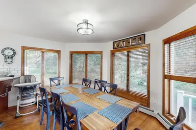 a dining room with a table and chairs and windows at Beach and Dock! Group-Friendly Albrightsville Gem in Towamensing Trails