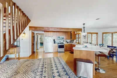 a kitchen with a stairway and a kitchen with a counter at Beach and Dock! Group-Friendly Albrightsville Gem in Towamensing Trails