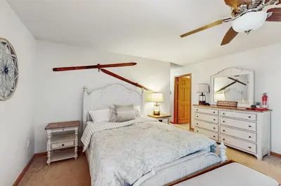 a bedroom with a bed and a clock on the wall at Beach and Dock! Group-Friendly Albrightsville Gem in Towamensing Trails
