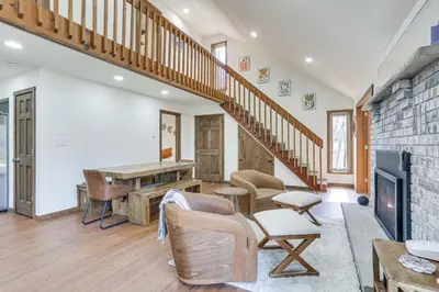 a living room with a staircase and chairs at Pocono Mountain Family Home with Deck and Grill in Saw Creek