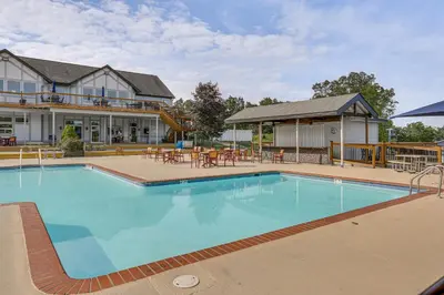 a large swimming pool in front of a house at Pocono Mountain Family Home with Deck and Grill in Saw Creek