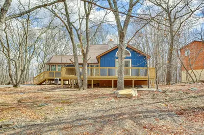 a large blue house with a large deck at Pocono Mountain Family Home with Deck and Grill in Saw Creek