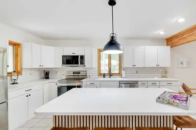 a kitchen with white cabinets and a white counter top at Woodlands Hideaway- Hot Tub Grill & Games in Albrightsville