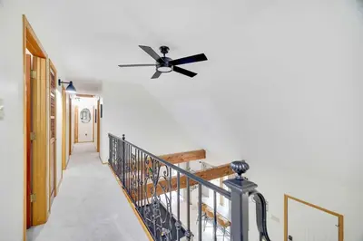 a hallway with a ceiling fan and a staircase at Woodlands Hideaway- Hot Tub Grill & Games in Albrightsville