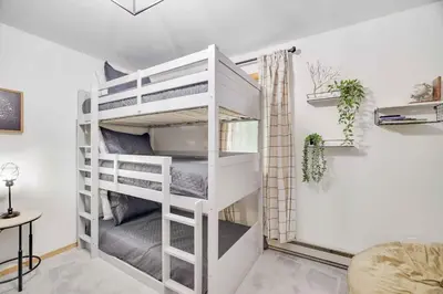 a white bunk bed in a room with a desk at Woodlands Hideaway- Hot Tub Grill & Games in Albrightsville