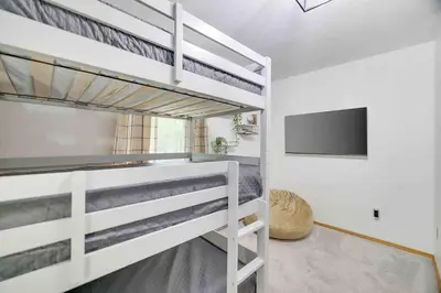 a bedroom with bunk beds and a flat screen tv at Woodlands Hideaway- Hot Tub Grill & Games in Albrightsville