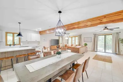 a kitchen and living room with a large dining table at Woodlands Hideaway- Hot Tub Grill & Games in Albrightsville