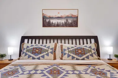 a bed with two pillows and a picture on the wall at Cozy Freeland Retreat- Firepit Pool Table Hot Tub in White Haven