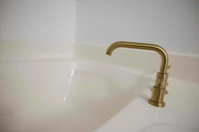 a white sink with a gold faucet at Cozy Freeland Retreat- Firepit Pool Table Hot Tub in White Haven