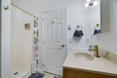 a white bathroom with a sink and a shower at Cozy Freeland Retreat- Firepit Pool Table Hot Tub in White Haven