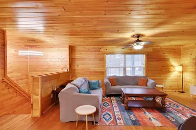 a living room with wooden walls and a couch and a table at Cozy Freeland Retreat- Firepit Pool Table Hot Tub in White Haven