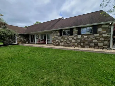 a brick house with a lawn in front of it at Bridle Pool House in Lansdale