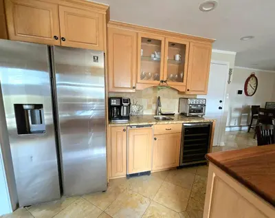 a kitchen with wooden cabinets and a stainless steel refrigerator at Bridle Pool House in Lansdale