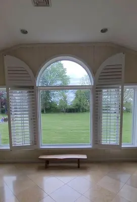 an empty room with three large windows with a bench in front at Bridle Pool House in Lansdale
