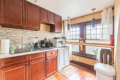 a kitchen with wooden cabinets and a sink at Quaint 3rd Floor Loft in Highland Park