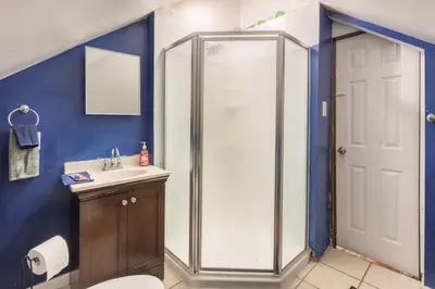 a bathroom with a shower and a sink at Quaint 3rd Floor Loft in Highland Park