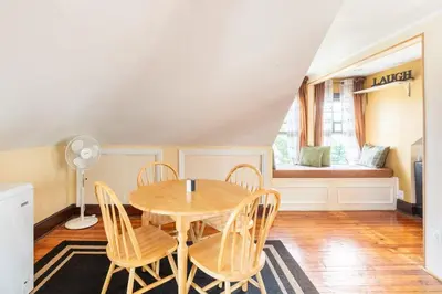 a dining room with a table and chairs and a window at Quaint 3rd Floor Loft in Highland Park