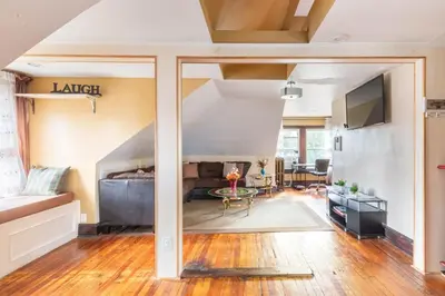 a living room with a bed and a table at Quaint 3rd Floor Loft in Highland Park