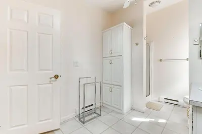 a white bathroom with a door and a mirror at Family Home in Arrowhead Lake with Fire Pit! in Pocono Lake