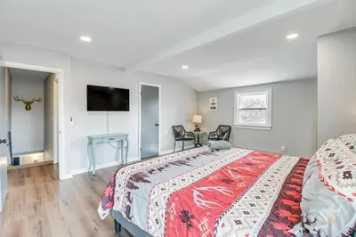 a bedroom with a bed and a tv on the wall at Fire Pit and Game Room Spacious Poconos Retreat! in Long Pond
