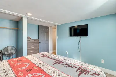 a bedroom with a bed with a tv on the wall at Fire Pit and Game Room Spacious Poconos Retreat! in Long Pond