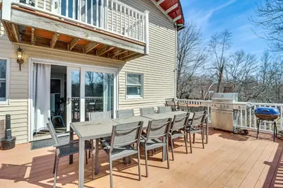 a deck with a table and chairs on a house at Fire Pit and Game Room Spacious Poconos Retreat! in Long Pond