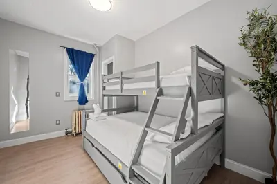 a bedroom with two bunk beds with white walls at Spacious Stay Near EWR And NYC Mins to Train in Bayonne