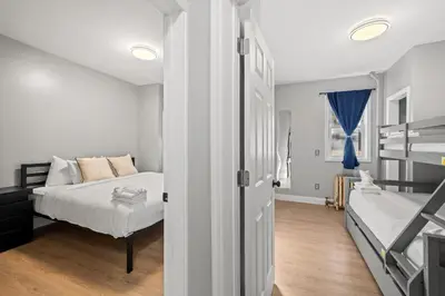 a bedroom with a bed and a bed and a window at Spacious Stay Near EWR And NYC Mins to Train in Bayonne