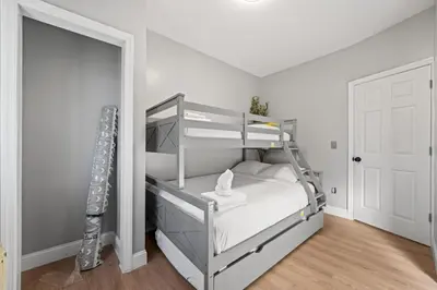 a bedroom with a bunk bed and a white door at Spacious Stay Near EWR And NYC Mins to Train in Bayonne