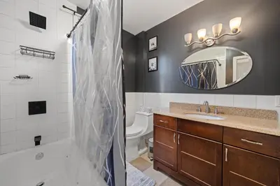 a bathroom with a shower and a sink and a mirror at Spacious Stay Near EWR And NYC Mins to Train in Bayonne