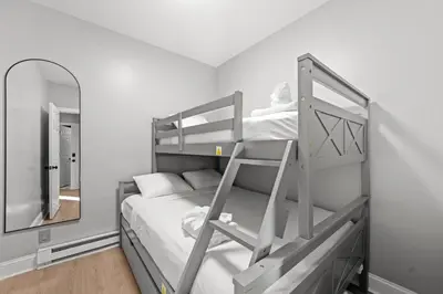 a bedroom with a bunk bed and a mirror at Spacious Stay Near EWR And NYC Mins to Train in Bayonne