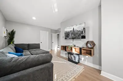 a living room with a couch and a fireplace at The City Spacious Stay Near EWR And NYC Mins to Train in Bayonne
