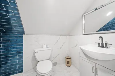 a bathroom with a white toilet and a sink at The City Spacious Stay Near EWR And NYC Mins to Train in Bayonne