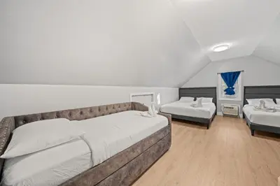 a large bedroom with two beds and a couch at The City Spacious Stay Near EWR And NYC Mins to Train in Bayonne