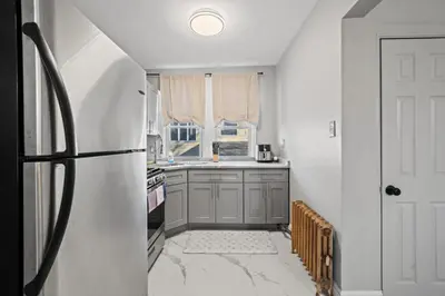 a kitchen with a refrigerator and a window at The City Spacious Stay Near EWR And NYC Mins to Train in Bayonne