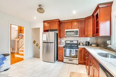 a kitchen with wooden cabinets and a stainless steel refrigerator at Work, Explore and Relax Centrally Located Union Gem in Union