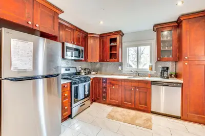 a kitchen with wooden cabinets and stainless steel appliances at Work, Explore and Relax Centrally Located Union Gem in Union