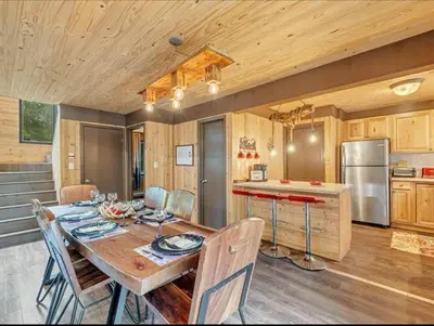 a kitchen and dining room with a wooden table and chairs at Cabin Retreat with Hot Tub in Pocono Country Place