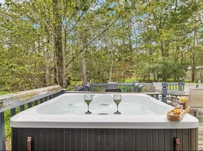 two glasses of wine sitting on a hot tub at Cabin Retreat with Hot Tub in Pocono Country Place