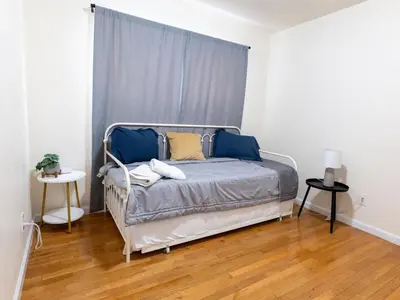 a bedroom with a bed with blue and yellow pillows at New 4 Apts-198-3 Bed Apt 1st Floor & 3 Bed Apt 2nd Floor - 1 Bed Studio Apt Ground Floor & 1 Bed Studio Apt Ground Floor near Penn Station EWR Newark NJ Airport Hospital Manhattan NYC in Newark