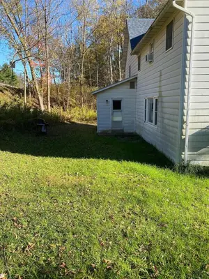 a white house with a yard next to a house at LARGE Open Floor Plan for Your Entertainment with a Short Walk to West Branch Delaware for Water fun and Fishing in Hancock