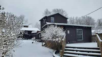a house with snow on the ground next to a fence at Newton Lake in Malinchak Airport