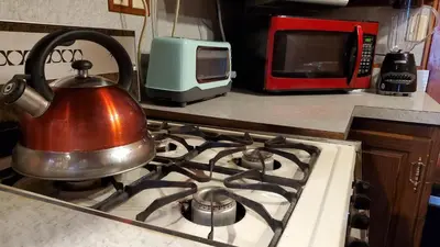 a tea kettle on top of a stove in a kitchen at Newton Lake in Malinchak Airport
